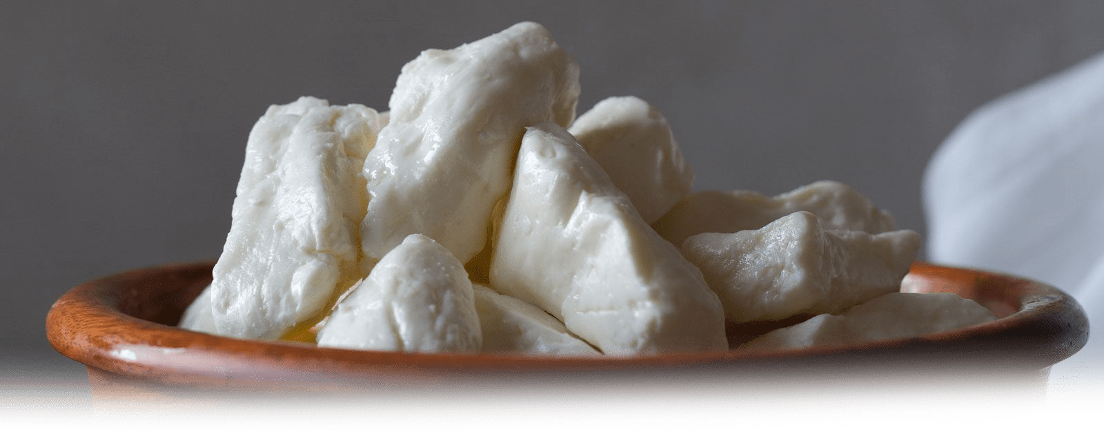 Close-up of fresh MouCo Cheese Curds in a wooden bowl—highlighting their plump, creamy texture and small-batch quality.