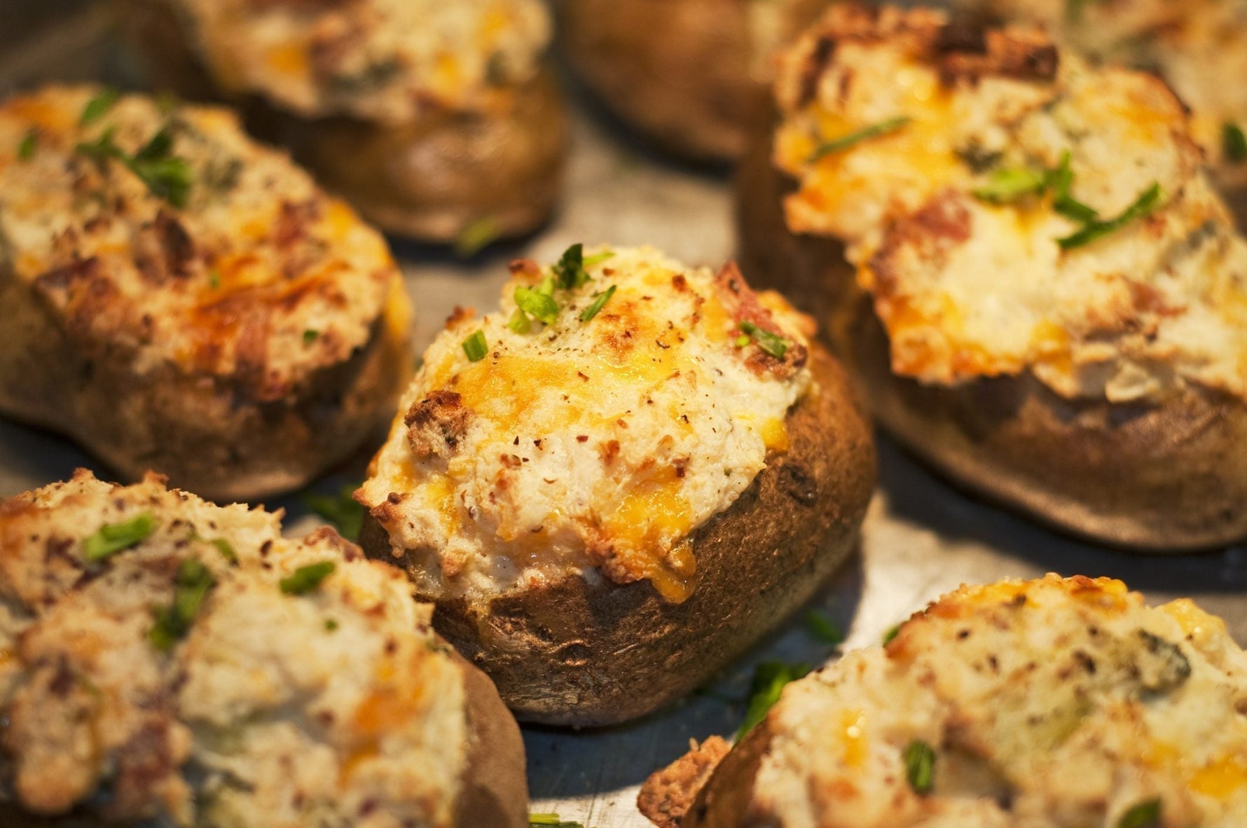 Baked russet potato split open and filled with melting MouCo Camembert, topped with chives—crispy on the outside, rich and creamy inside.
