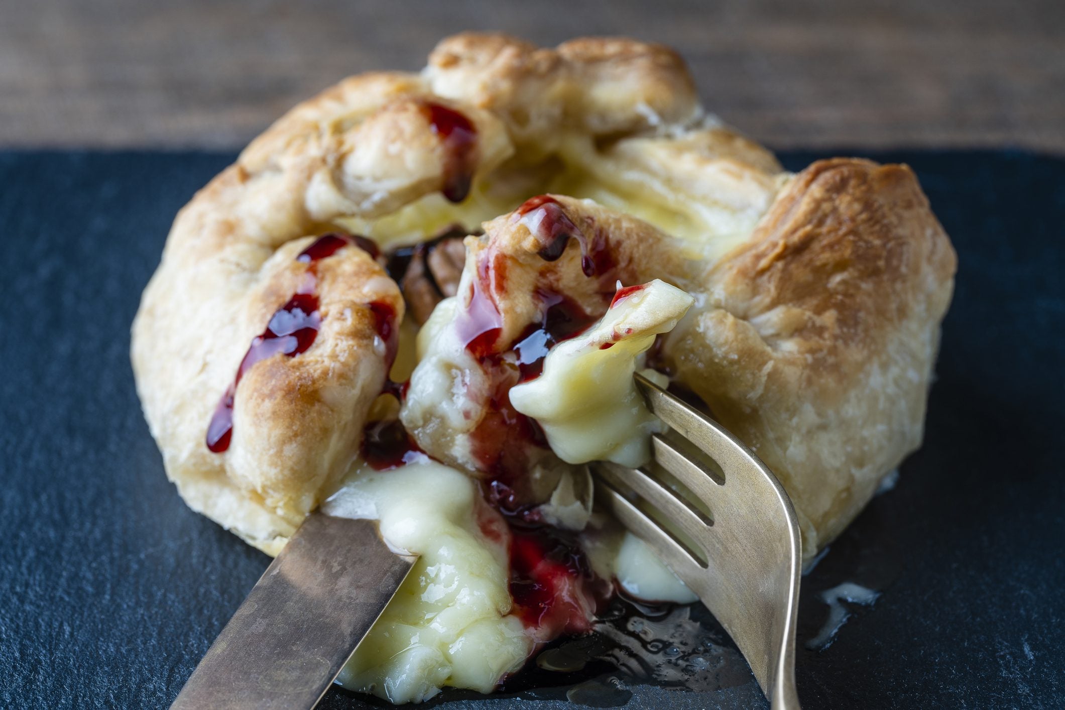 Golden puff pastry-wrapped MouCo Camembert oozing with berry jam—baked to perfection and ready to slice for kids, guests, or your own cozy indulgence.