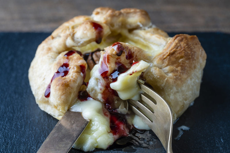 Golden puff pastry-wrapped MouCo Camembert oozing with berry jam—baked to perfection and ready to slice for kids, guests, or your own cozy indulgence.