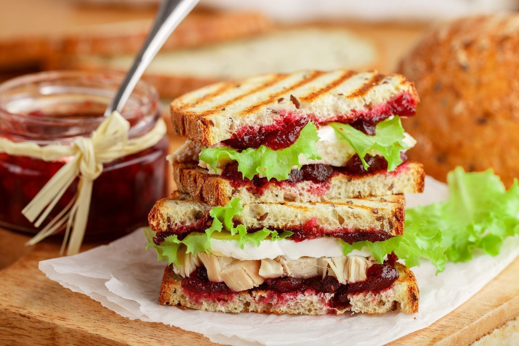 Golden toasted grain panini filled with MouCo Camembert, turkey, cranberry sauce, and crisp greens—a melty, savory-sweet upgrade for lunchboxes or grown-up brunches.