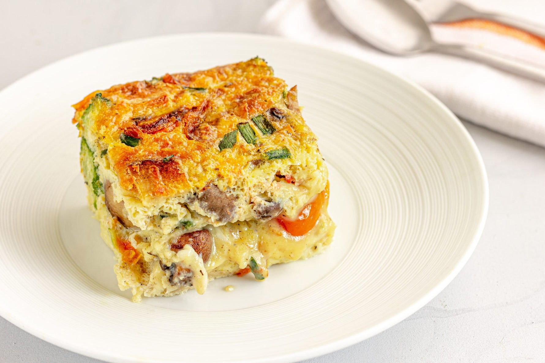 Baked strata layered with MouCo Ashley cheese, fresh chives, and golden bread—rich, savory, and a great weekend project to make with kids.