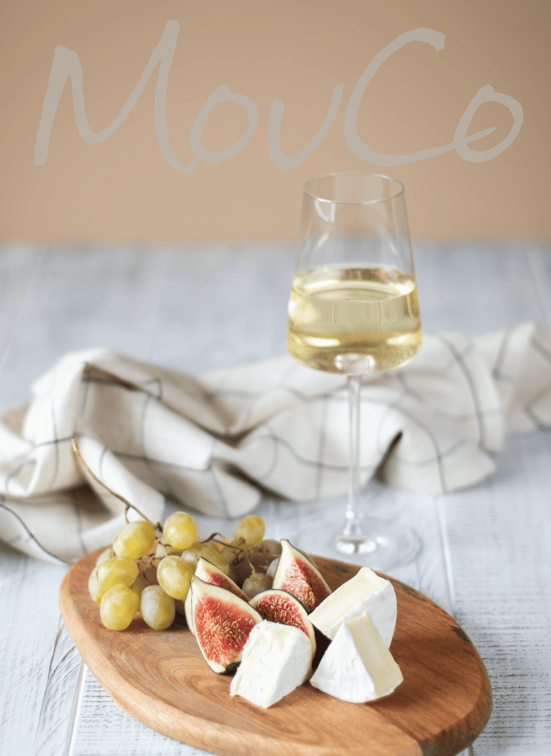 Creamy MouCo Camembert paired with fresh figs and a glass of Champagne—rich, sweet, and crisp flavors in balance.