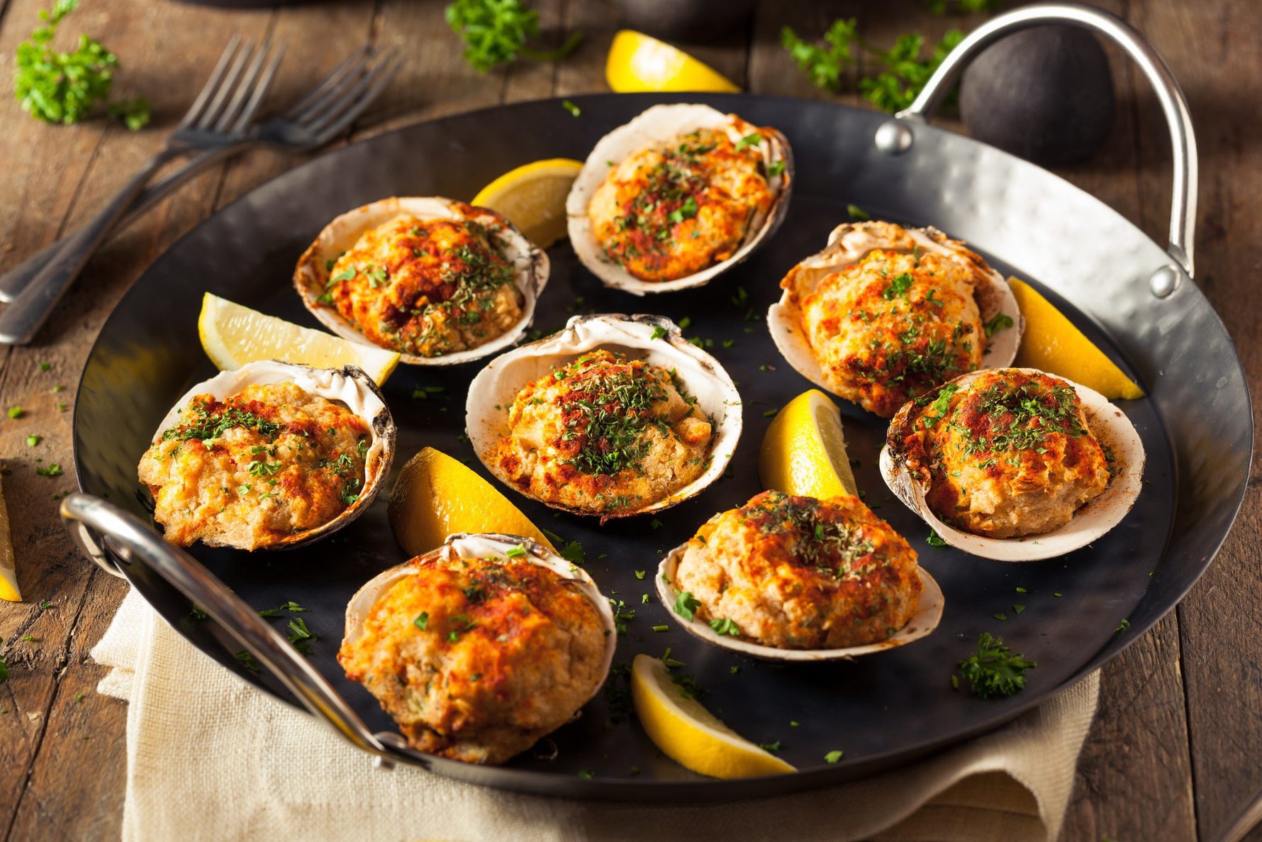 Grilled clams topped with MouCo ColoRouge, bacon, peppers, and parsley—smoky, melty, and brightened with a squeeze of lemon.