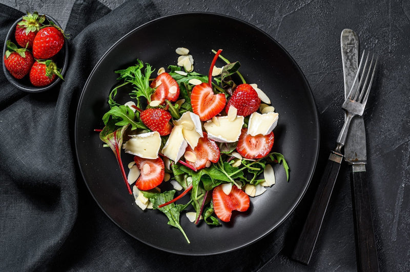 Arugula salad with sliced strawberries and crumbled MouCo Camembert, drizzled with balsamic dressing—sweet, creamy, and peppery in perfect harmony.