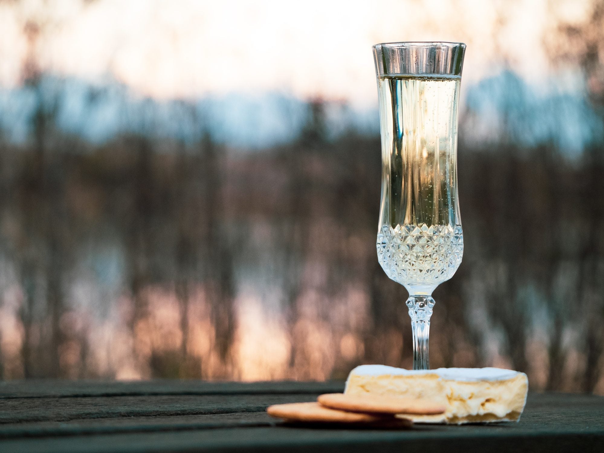 Champagne flute garnished with a skewer of MouCo Camembert and fresh fig—creamy, sweet, and bubbly with a playful, elegant twist.