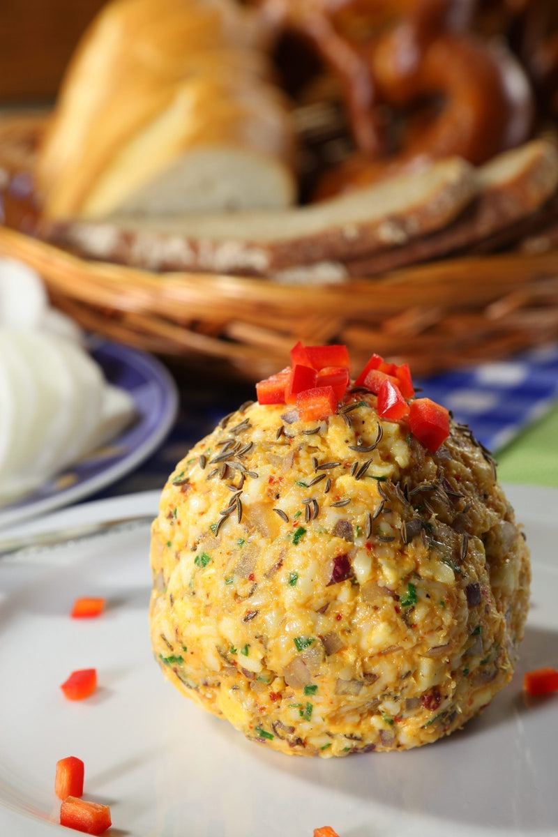 Bite-sized Bavarian Obatzda cheese balls made with MouCo Camembert, coated in crushed pretzels and topped with fresh chives—a creamy, crunchy snack fit for beer gardens or lunchboxes alike.