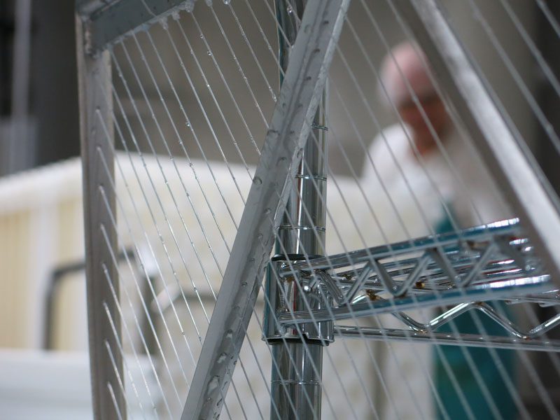 Cutting: Close-up of MouCo’s curd-cutting harp—razor-sharp blades and fine tensioned line slice cleanly through the curd like a grid of swords in motion.