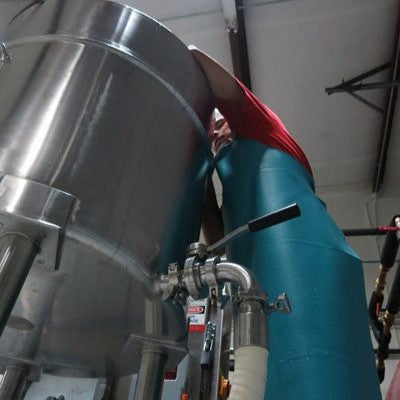 Cheese Making Begins: Looking up as the cheesemaker adds cultures and raw materials—kickstarting a fresh batch in the quiet early hours.