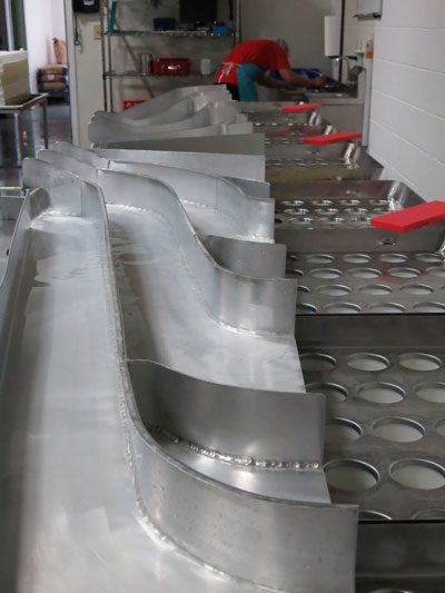 Forming: Overhead view of MouCo’s ALPMA curd delivery system—German-engineered precision built to fill 180 cheeses at once with food-grade stainless and clean design.