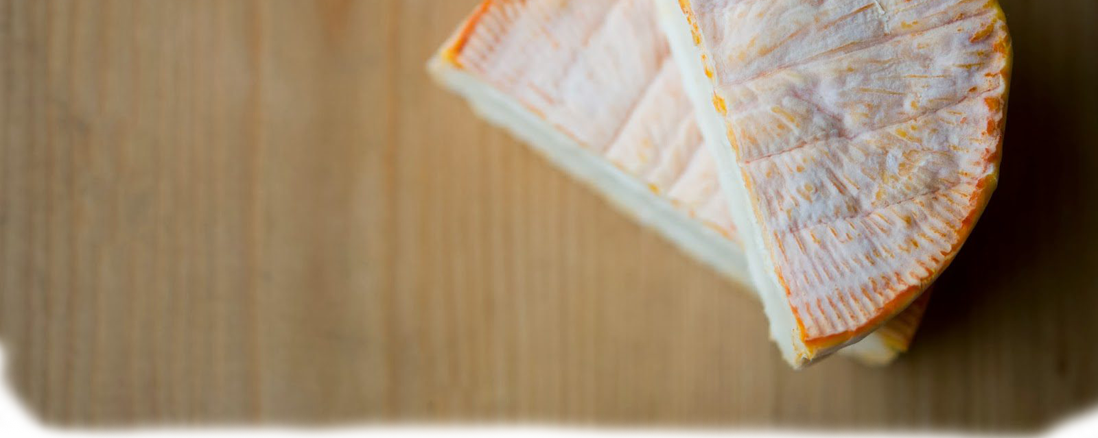 A top-down look at a halved MouCo ColoRouge—showcasing the award-winning rind where three microbes work in harmony to create its signature dusty bloom, deep orange tones, and just-right funk.