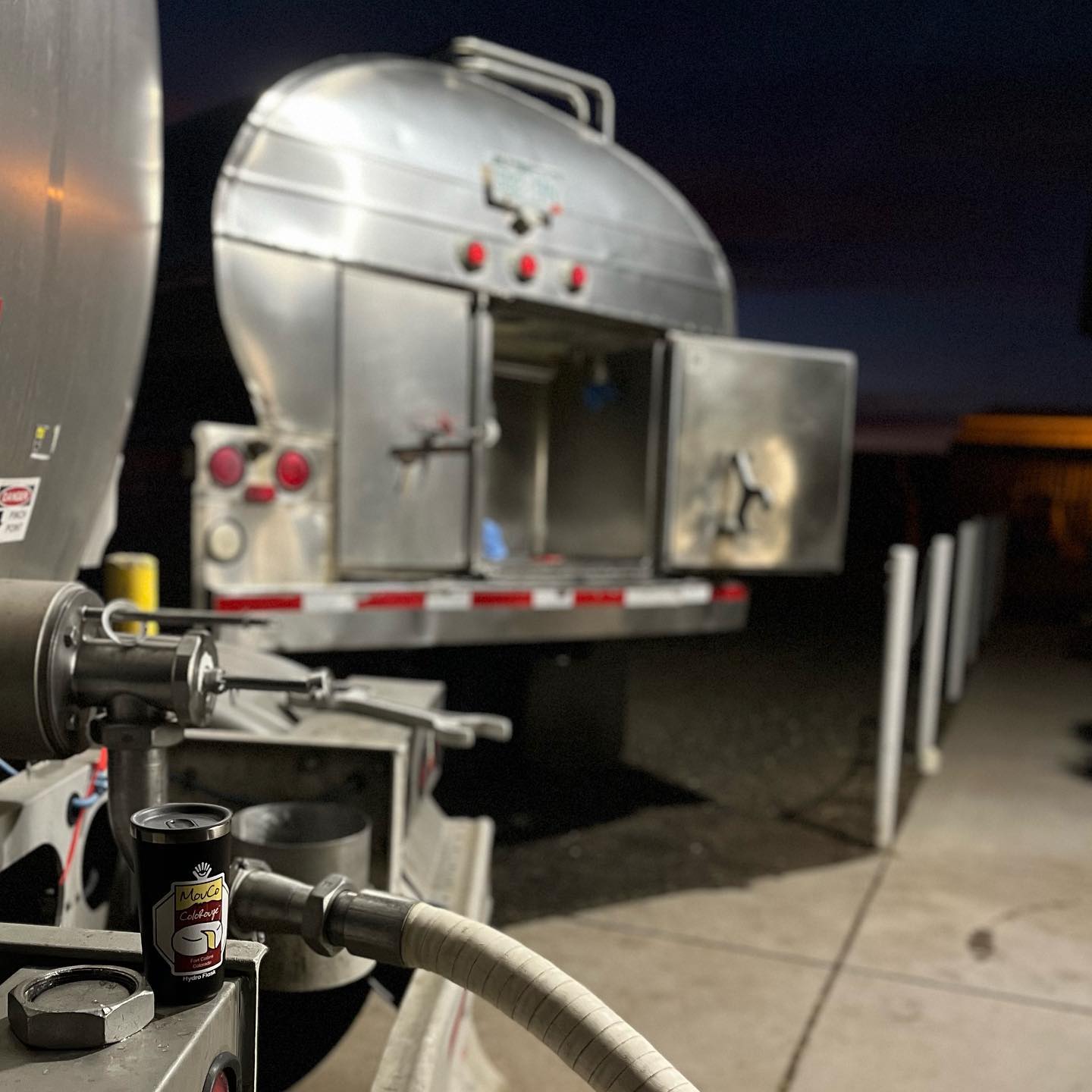 Bringing in the Milk: Chuck waits to load while the day starts strong—with coffee in a MouCo mug and a view built for cheese runs.