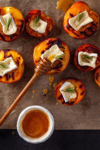 Grilled Peaches with MouCo Camembert, Rosemary, and Honey