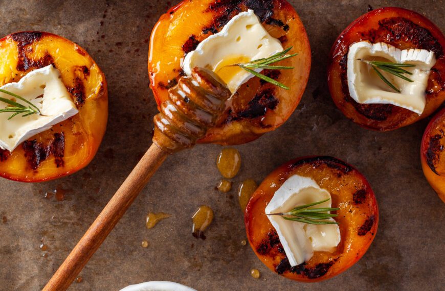 Grilled peaches with MouCo Camembert cheese, rosemary, and honey.